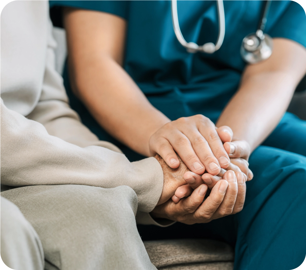 Healthcare worker comforting patient with hand touch.