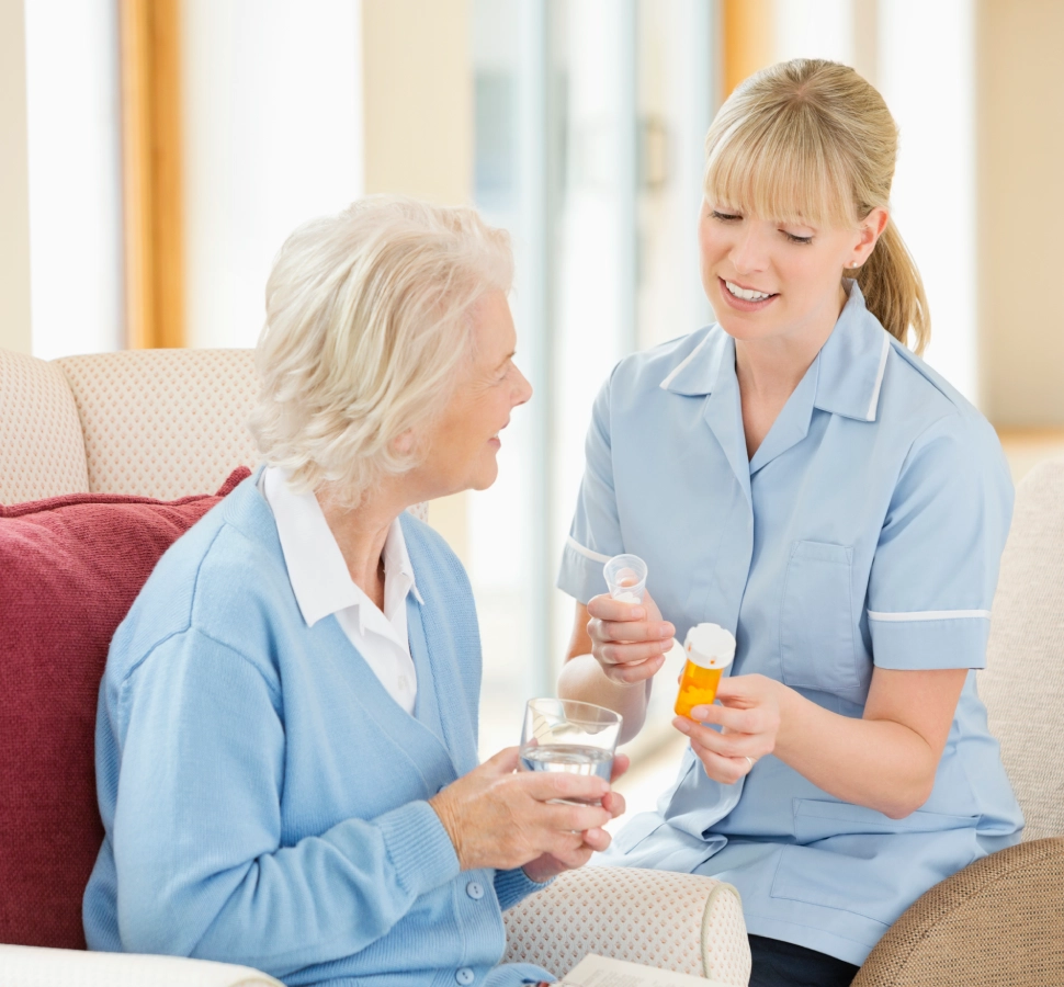 Nurse assisting elderly woman with medication.